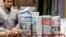 A man takes a copy of newspaper at a grocery shop in Shah Alam, Malaysia, Monday, March 26, 2018. Malaysia's government on Monday proposed new legislation to outlaw fake news with a 10-year jail term for offenders, in a move slammed by critics as a draconian bid to crack down on dissent ahead of a general election.