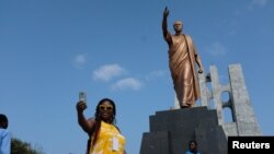Mwanamke akipiga picha mbele ya sanamu ya aliyekuwa rais wa Ghana Kwameh Nkrumah, mjini Accra, August 7, 2019. PICHA:. REUTERS/Francis Kokoroko 