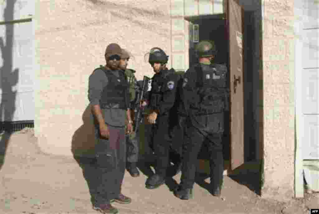 Israeli riot police stand guard outside of Beit Yonatan, a building that houses seven Jewish families and a religious learning center, during clashes with Palestinian youth, not seen, in the east Jerusalem neighborhood of Silwan, Monday, Dec. 27, 2010. Te