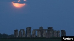 The full moon, known as the "Super Flower Moon", is seen behind Stonehenge stone circle near Amesbury, Britain, May 26. REUTERS/Peter Cziborra