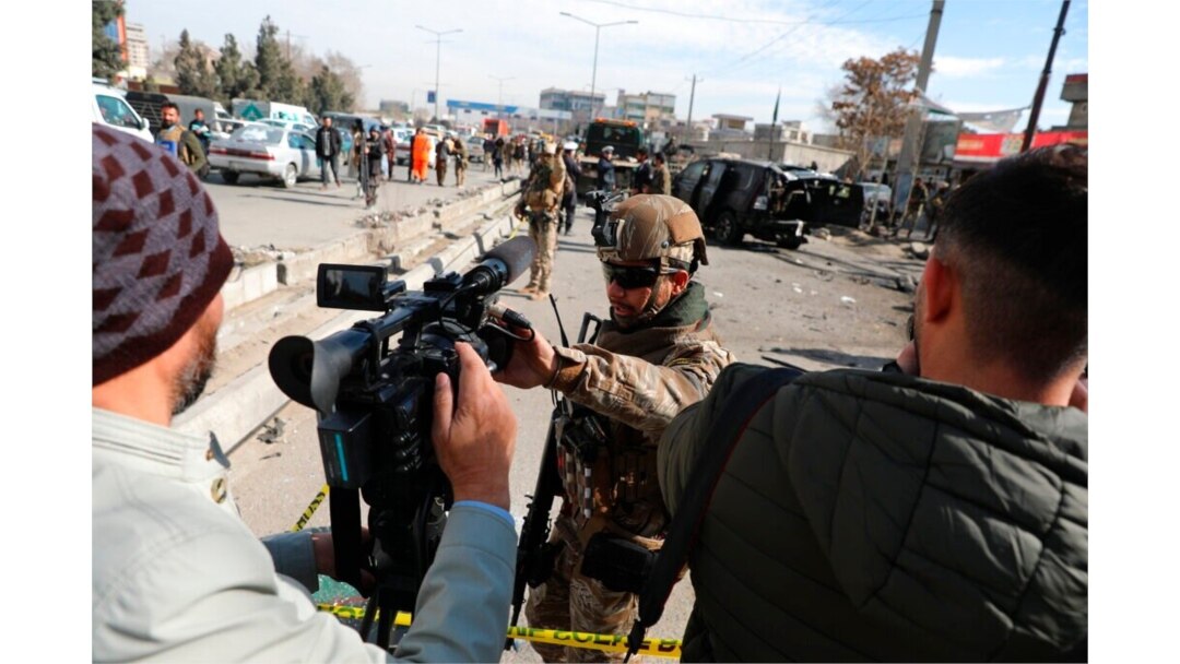 FILE - Afghan security police block a TV journalist from filming at the site of bombing attack in Kabul, Afghanistan, Feb. 10, 2021.