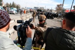 FILE - Afghan security police block a TV journalist from filming at the site of bombing attack in Kabul, Afghanistan, Feb. 10, 2021.