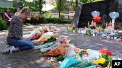 ARCHIVO - Un visitante reza en un monumento a las siete personas muertas y otras heridas en el tiroteo masivo del 4 de julio en el Highland Park War Memorial en Highland Park, Illinois, el 7 de julio de 2022.