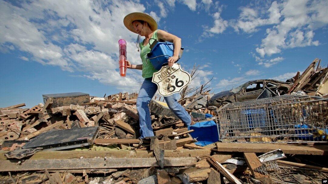 Susan Kates, warga setempat, berusaha menyelamatkan beberapa barangnya di antara reruntuhan rumahnya yang hancur akibat badai tornado di kota Moore, Oklahoma (22/5).