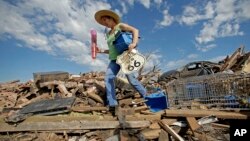 Susan Kates, warga setempat, berusaha menyelamatkan beberapa barangnya di antara reruntuhan rumahnya yang hancur akibat badai tornado di kota Moore, Oklahoma (22/5).