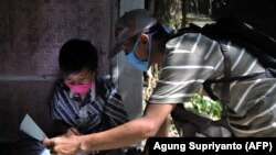 Guru SD Fransiscus Xaverius Fri Harna (kanan) mengajar di rumah siswanya di Magelang, Jawa Tengah, usai sekolah tutup akibat wabah virus Corona COVID-19. Beberapa guru mengambil medan berbahaya, cuaca buruk dan risiko tertular COVID-19, untuk menjangkau s