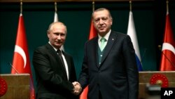 Turkey's President Recep Tayyip Erdogan, right, shakes hands with Russia's President Vladimir Putin, left, following their joint news statement after their meeting at the Presidential Palace in Ankara, Dec. 11, 2017. 