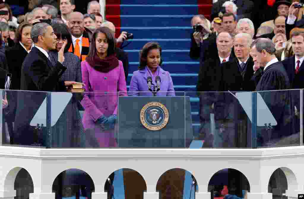 President Barack Obama, L, is sworn-in for a second term by Supreme Court Chief of Justice John Roberts, R, during his public inauguration ceremony at the U.S. Capitol in Washington, D.C., Jan. 21, 2013, while wife Michelle (L-R) and daughters Sasha and Malia look on.