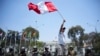 ARCHIVO - Un manifestante ondea una bandera peruana frente al Congreso para protestar por la situación de seguridad del país, en Lima, Perú, el 23 de octubre de 2024. 