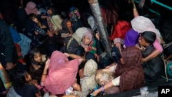 Pengungsi Rohingya duduk di perahu mereka saat tiba di Pelabuhan Krueng Geukueh di Aceh Utara, Jumat dini hari, 31 Desember 2021. (Foto: AP)