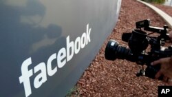 Seorang awak kamera televisi mengambil gambar logo Facebook di kantor pusat Facebook di Menlo Park, California, 18 Mei 2012.