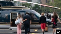 New York Gov. Andrew Cuomo and others walk towards a helicopter at a Manhattan heliport in New York on Tuesday, Aug. 10, 2021. 