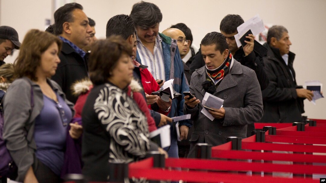 FILE - Nonresident visitors to the United States wait in line at immigration control after arriving at McCarran International Airport, in Las Vegas, Dec. 13, 2011.