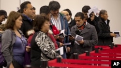 FILE - Nonresident visitors to the United States wait in line at immigration control after arriving at McCarran International Airport, in Las Vegas, Dec. 13, 2011.