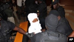 FILE - Security personnel surround former Chadian dictator Hissene Habre inside a courtroom in Dakar, Senegal, July 20, 2015.