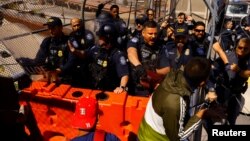 U.S. Customs and Border Protection agents confront migrants during a protest at the Paso del Norte international bridge to request asylum in the United States, seen from Ciudad Juarez, Mexico, March 12, 2023.