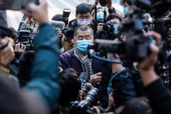 FILE - Hong Kong pro-democracy media tycoon Jimmy Lai, center, arrives at the Court of Final Appeal in Hong Kong on Dec. 31, 2020, to face the prosecution's appeal against his bail after he was charged with the new national security law.