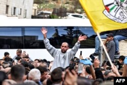 One of the Palestinian prisoners released by Israel gestures as he is surrounded by people cheering after disembarking from a Red Cross bus in Ramallah in the occupied West Bank on Jan. 25, 2025.