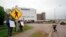 FILE - Residents hold 'thank you' signs to greet employees of a Smithfield pork processing plant in Sioux Falls, South Dakota, May 20, 2020, as they resume working after the plant's three-week closure because of a coronavirus outbreak.