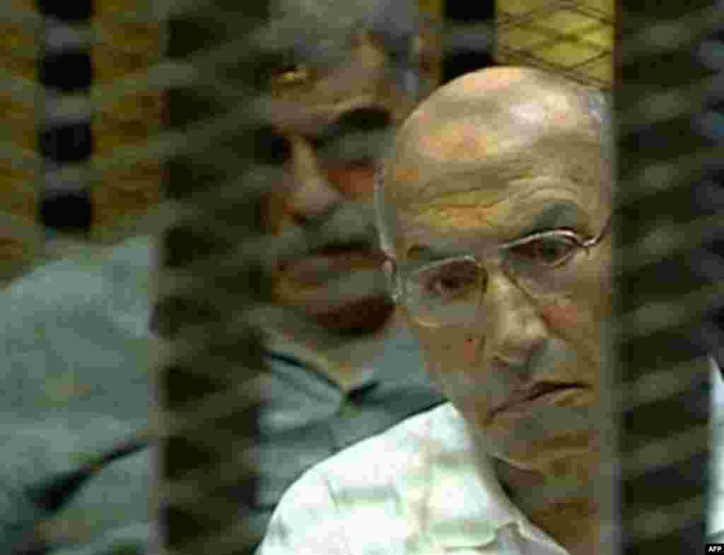 This video image taken from Egyptian State Television shows Ahmed Ramzy, former commander of the Egyptian riot police, known formally as Central Security Forces, in a cage of mesh and iron bars during his trial in a Cairo courtroom Thursday Aug. 4, 2011. 