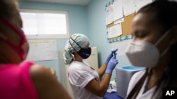 Una enfermera se prepara para inocular a un trabajador de la salud con una dosis de la vacuna Sinopharm contra el COVID-19 en un centro de salud del programa de salud del gobierno en Caracas, Venezuela. Marzo 7, 2021.