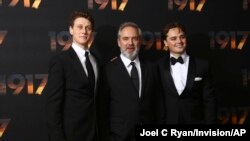Actor George MacKay, from left, director Sam Mendes and actor Dean-Charles Chapman pose for photographers upon arrival at the World premiere of the film '1917', in central London, Dec. 4, 2019. 