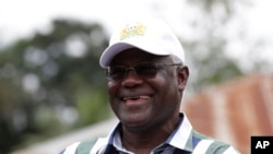 FILE - In this photo taken on August 14, 2015, Sierra Leone President Ernest Bai Koroma, cuts the tape to release people from quarantine in the village of Massessehbeh on the outskirts of Freetown, Sierra Leone.