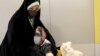 یک زن ایرانی در حال دریافت واکسن چینی در مرکز خرید «ایران مال» در تهران