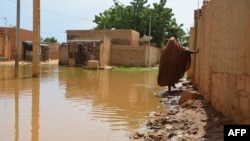 Une personne marche dans une rue inondée dans le district de Saga, Niamey, 11 septembre 2017.