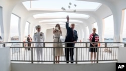 Rais Donald Trump na mkewe Melania Trump, wakiwa na Kamanda Admirali Harry Harris, kushoto, na mkewe Bruni Bradley, wakipeperusha maua walipotembelea eneo la kumbukumbu la Pearl Harbor Memorial katika mji wa Honolulu, Hawaii, Novemba. 3, 2017. 