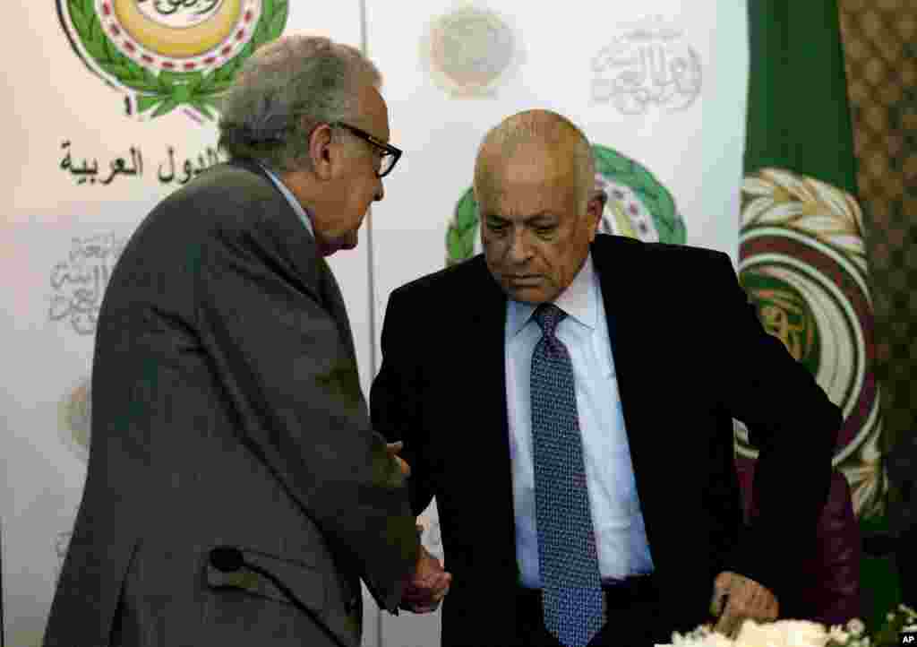 U.N.-Arab League envoy to Syria Lakhdar Brahimi, left, shakes hands with Arab League Secretary-General Nabil Elaraby following a joint press conference at the Arab League headquarters in Cairo, Egypt, December 30, 2012. 