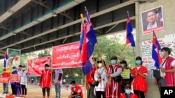 FILE - Anti-coup protesters hold a banner that reads “Karen National Group! Don’t want military dictatorship,” during a silent protest outside the Hledan Centre in Yangon, Myanmar, Feb. 21, 2021. 