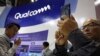 FILE - In this Nov. 6, 2018 file photo, attendees look at the latest technology from Qualcomm at the China International Import Expo in Shanghai. 