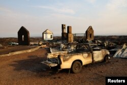 FILE - A view of a property and a vehicle destroyed by the fire near Pringle Bay in Western Cape, South Africa, January 30, 2024