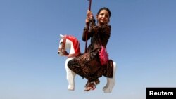 Una niña afgana en Kabul se divierte en un parque de atracciones en el primer día del festival sagrado musulmán de Eid-al-Adha.