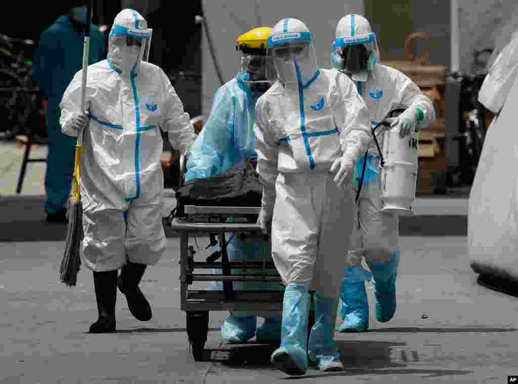 Health workers in protective suits transport a dead body at a hospital in Manila, Philippines.&#160;The capital and outlying provinces returned to another lockdown after medical groups warned that the country was waging a losing battle against the coronavirus.