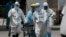 Health workers in protective suits transport a dead body at a hospital in Manila, Philippines. The capital and outlying provinces returned to another lockdown after medical groups warned that the country was waging a losing battle against the coronavirus.