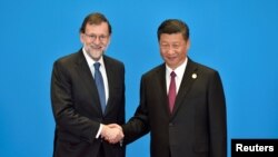 中国国家主席习近平在北京一带一路国际会议上与西班牙首相拉霍伊握手。（2017年5月15日）