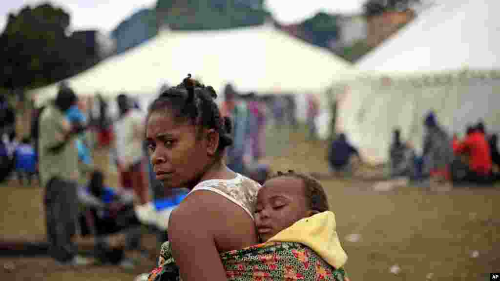 Un bébé sur le dos, une femme se promène dans un camp de réfugiés où plus de 2000 étrangers se sont abrités à Durban, en Afrique du Sud après les attaques meurtrières sur les immigrants, mercredi 15 avril 2015.