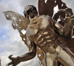FILE — A Mothman statue looks onto Main Street in Point Pleasant, West Virginia.