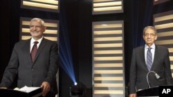 Egyptian presidential hopefuls Amr Moussa (R) and Abdel-Moneim Abolfotoh smile during a televised debate in Cairo May 10, 2012. 