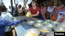 Catherine Bertini, mantan direktur eksekutif Program Pangan Dunia (WFP), membagikan makan siang di sebuah sekolah. (Foto: Dok)