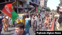 Ljudi nose avganistanske zastave na protestu u Džalalabadu, 18. avgusta 2021. (Foto: Reuters/Pajhwok Afghan News/Handout) 