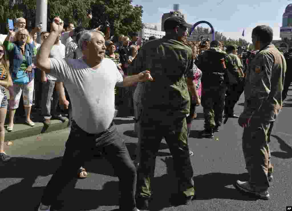 A man throws an egg at captured Ukrainian army prisoners as they're escorted by Pro-Russian rebels in a central square in Donetsk, eastern Ukraine, Aug. 24, 2014.