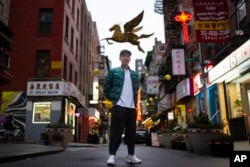 FILE - Karho Leung, 33, one of the founders of 12 Pell, a local barbershop, stands for his portrait on Pell Street in Manhattan's Chinatown neighborhood, Jan. 25, 2024, in New York.