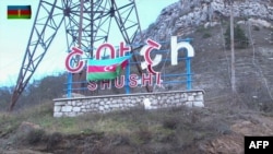 An image grab taken from a video made available on the official website of the Azerbaijani Defense Ministry Nov. 9, 2020, shows an Azeri flag on the side of a road entering the town of Shushi (Shusha) in the breakaway region of Nagorno-Karabakh.