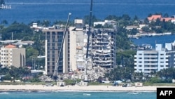 Cranes are seen at a partially collapsed building in Surfside, Florida, north of Miami Beach, on June 27, 2021.