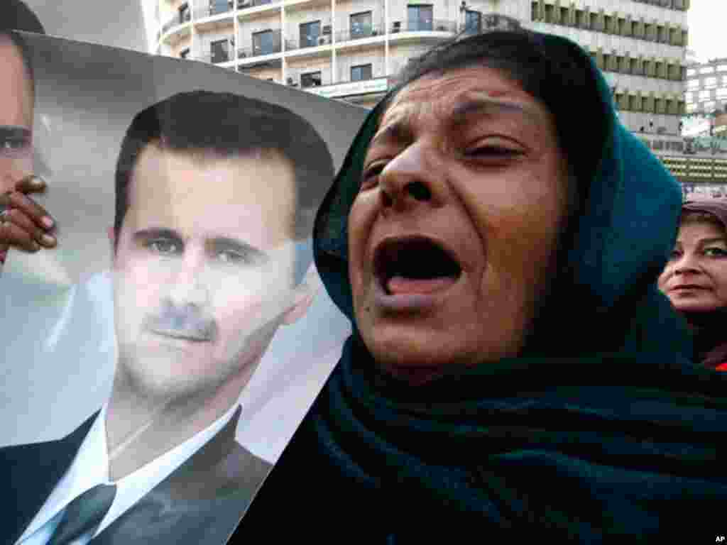 Pro-Syrian regime protesters shout slogans and holds portrait of Syrian President Bashar al-Assad during a demonstration to show their solidarity for their president, in Damascus, Syria, on January 25, 2102. (AP)