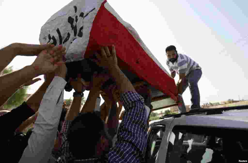 Residents transport the coffin of the former governor of Basra Mohammed Musabih Al-Waili during his funeral in Basra, September 28, 2012. 