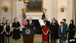 US President Joe Biden, standing alongside family members of the freed prisoners, speaks about the prisoner exchange with Russia, in the State Dining Room of the White House in Washington, DC, on August 1, 2024.